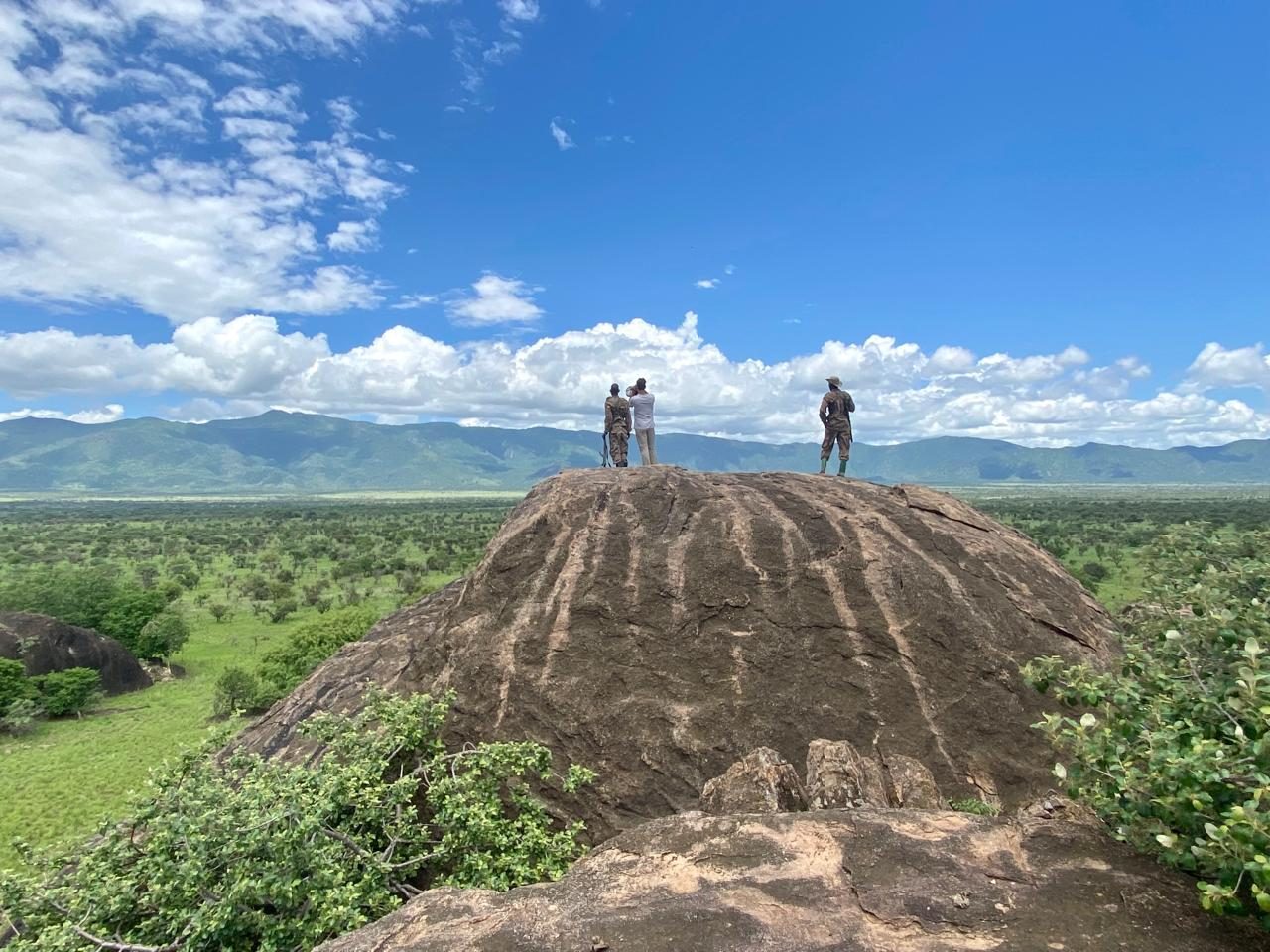 Rangers and a visitor on a granite kopje looking over the Zulia plains to the mountains